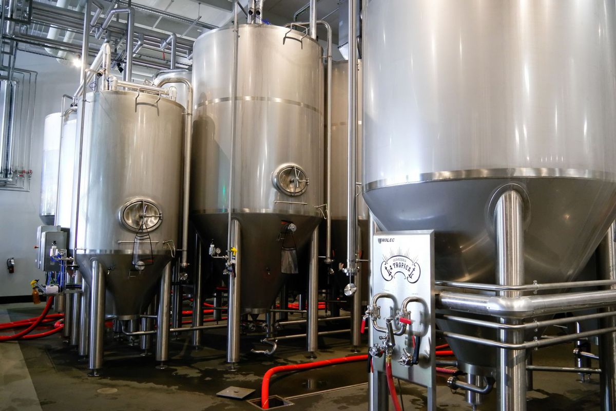 Sala de elaboración de las cervezas con varios tanques plateados grandes